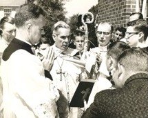 Bishop Sheen blessing the new buildings, surrounded by clergy and parishioners