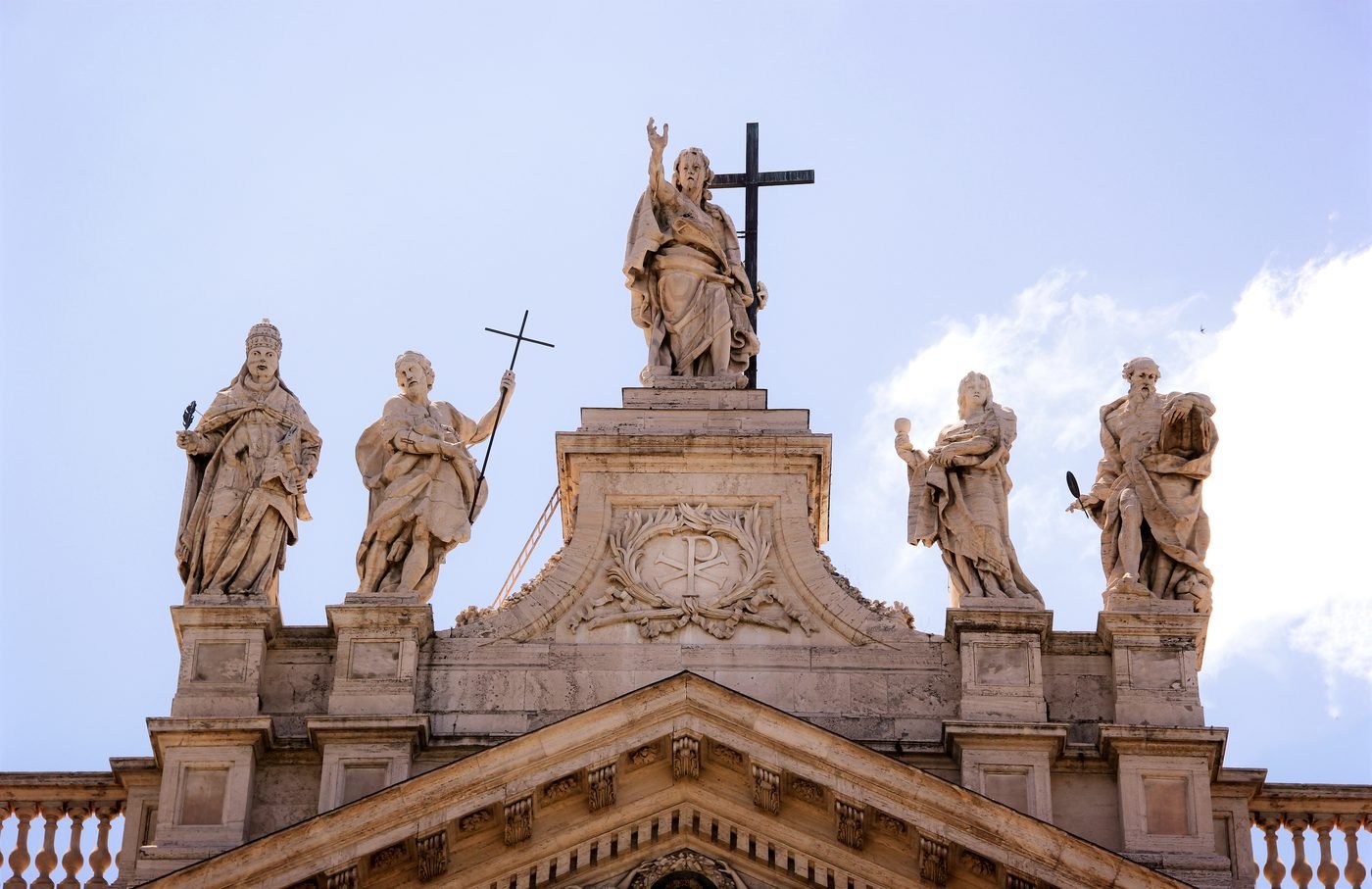 Rooftop statues of saints against the sky in Rome